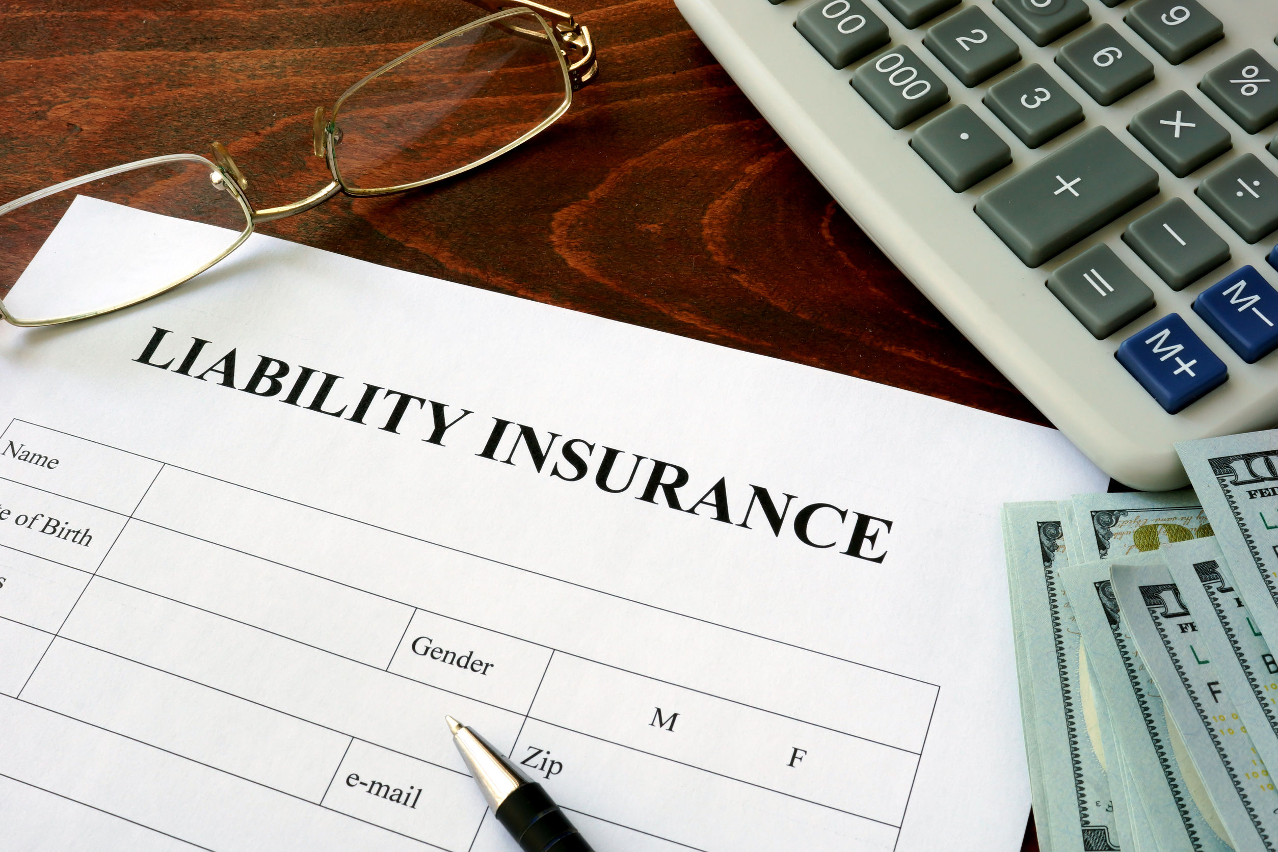 47220955 - liability insurance  form and dollars on the table.